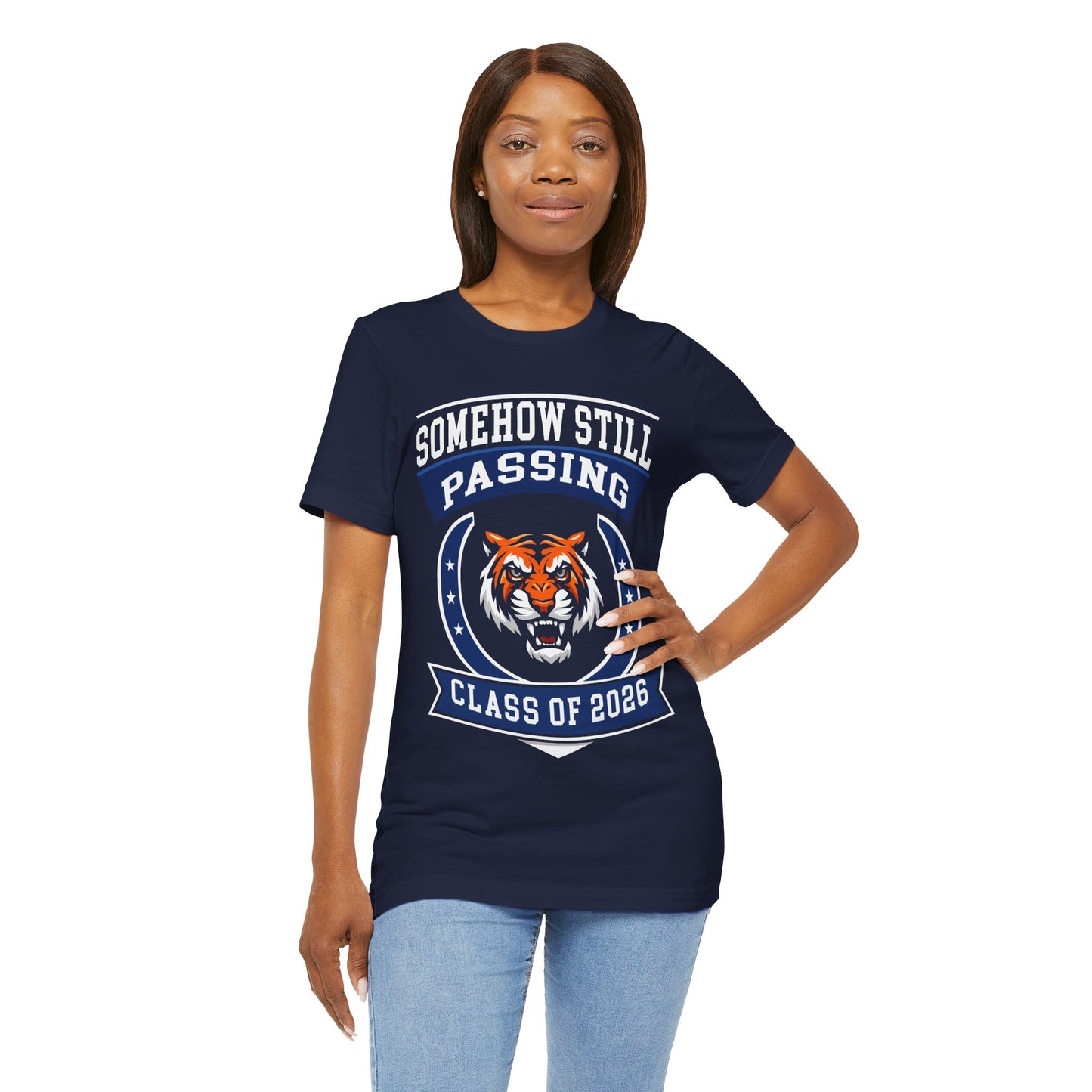 Somehow Still Passing — Funny Senior Tiger Tee (Class of 2026)