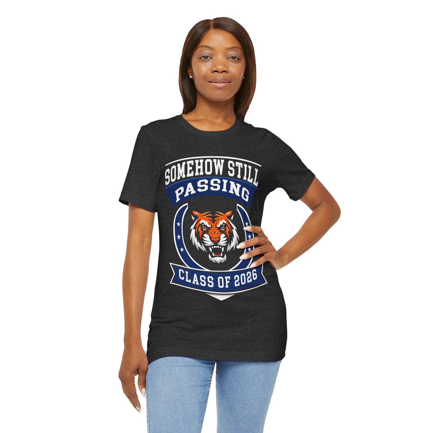 Somehow Still Passing — Funny Senior Tiger Tee (Class of 2026)