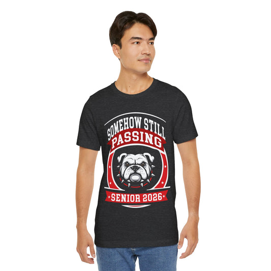 Somehow Still Passing — Funny Senior Bulldog Tee (Class of 2026)