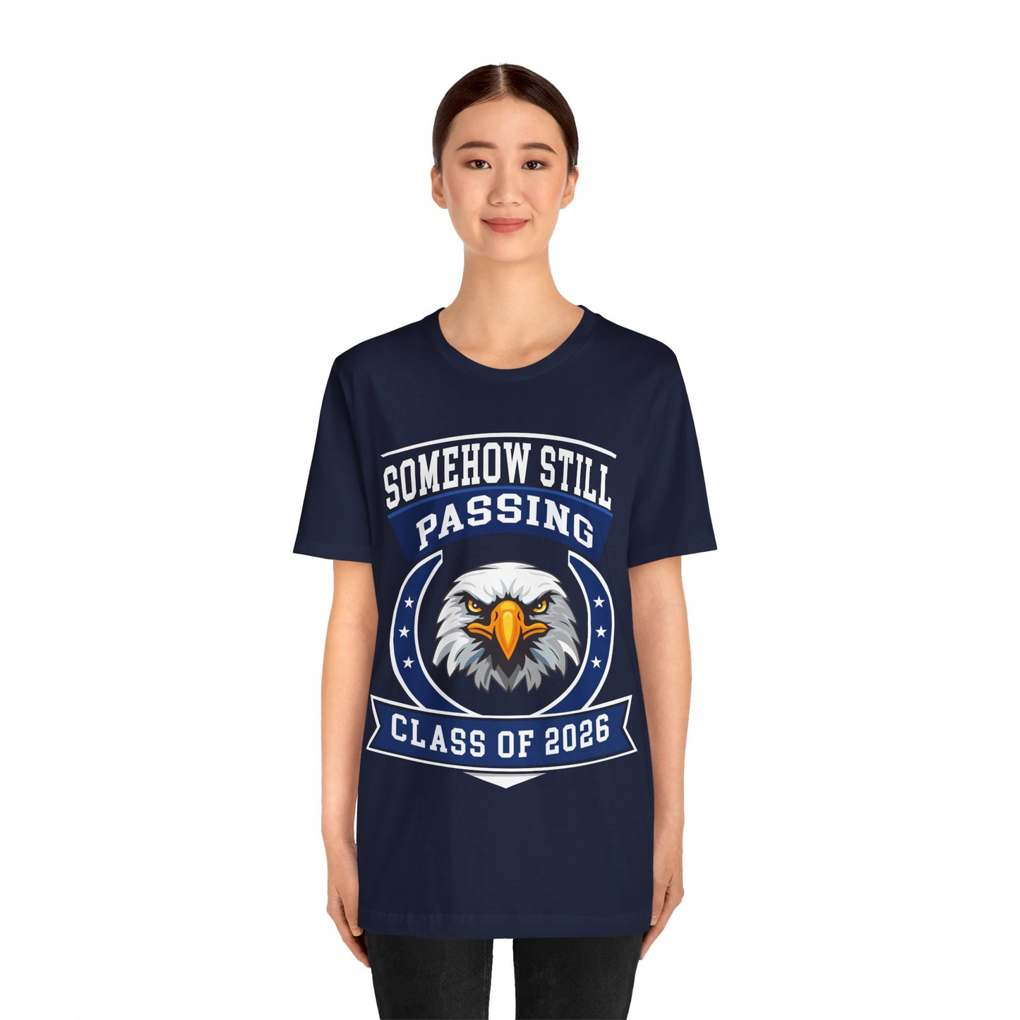 Somehow Still Passing — Funny Senior Eagle Tee (Class of 2026)