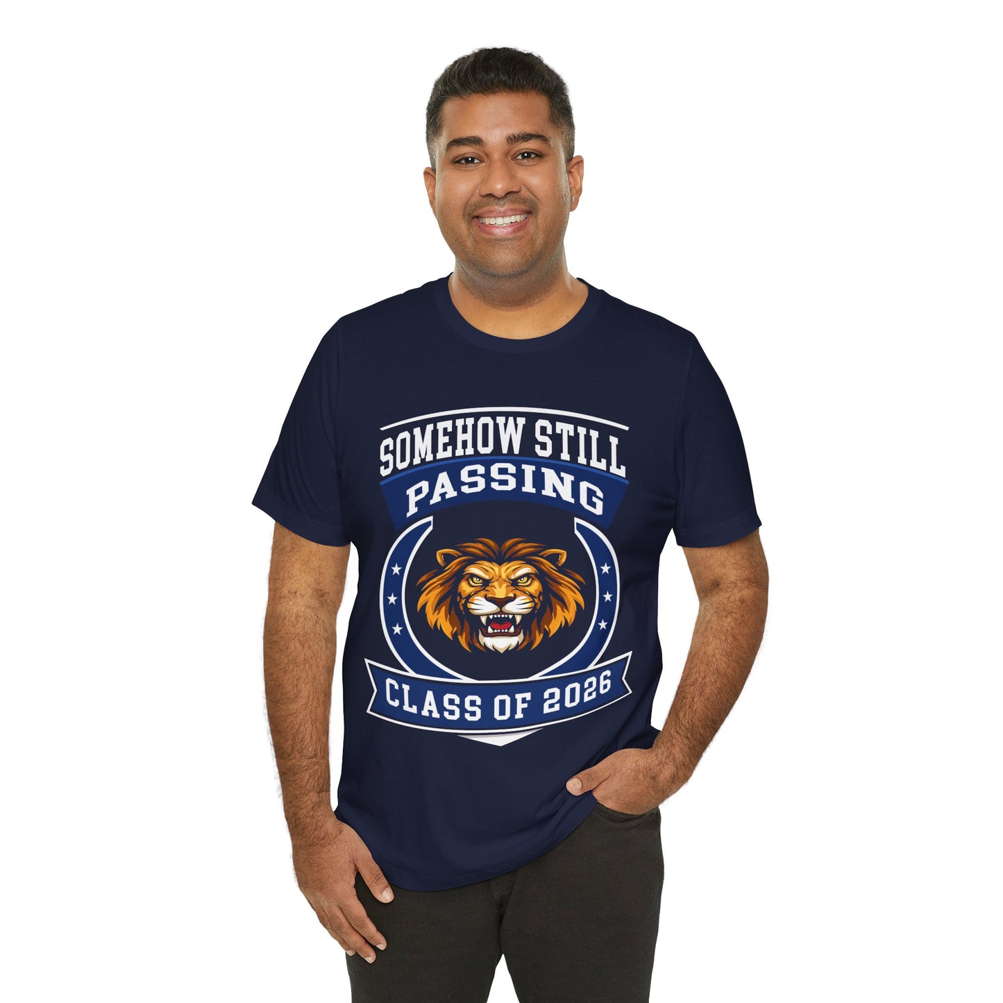Somehow Still Passing — Funny Senior Lion Tee (Class of 2026)