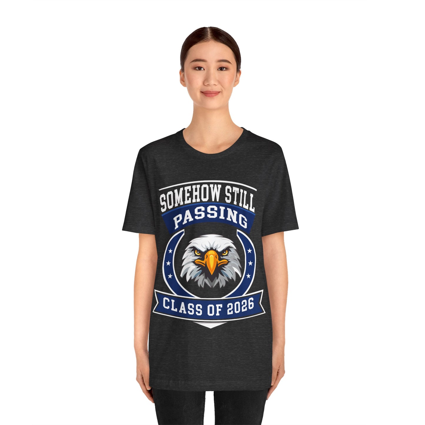 Somehow Still Passing — Funny Senior Eagle Tee (Class of 2026)