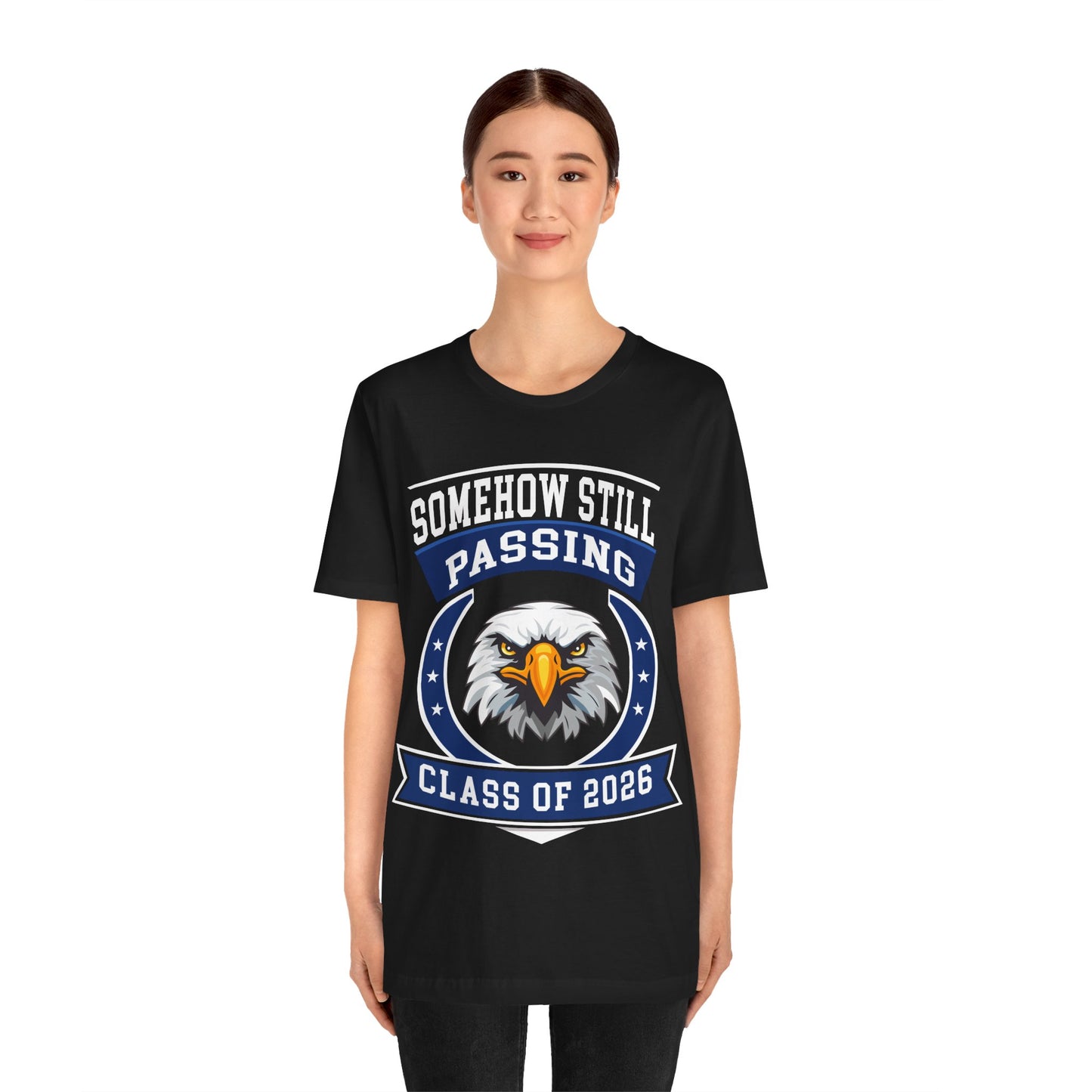 Somehow Still Passing — Funny Senior Eagle Tee (Class of 2026)