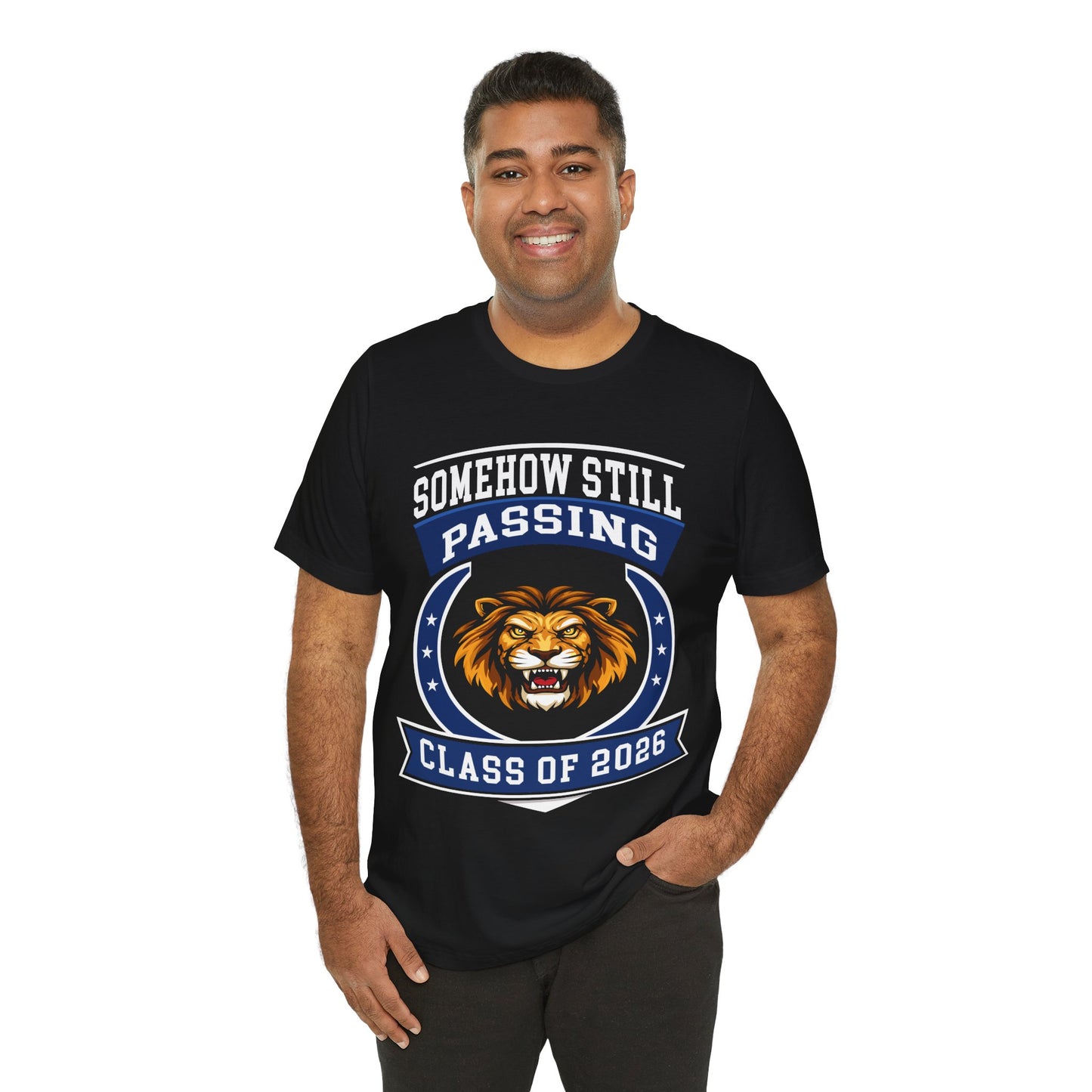 Somehow Still Passing — Funny Senior Lion Tee (Class of 2026)